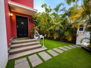 a house with a black door and a green lawn at Deluxe Coliving Islas Canarias in Las Palmas de Gran Canaria