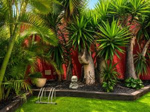 a garden with palm trees and a statue in the grass at Deluxe Coliving Islas Canarias in Las Palmas de Gran Canaria