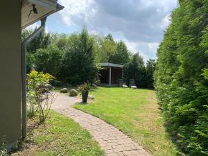 a garden with a walkway leading to a building at Das Schilfrohr in Neuendorf