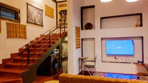 a living room with a staircase and a flat screen tv at Unique Homestay in Karatu