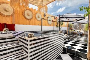 a patio with a hot tub and umbrellas at Riad Kamil 4Suites - Private Pool - Rooftop Lounge in Marrakesh