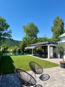 two chairs sitting on a patio near a lake at Unavis Residence in Bihać