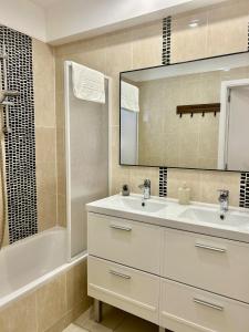 a bathroom with a sink and a mirror and a tub at Brussels Expo & Atomium Prestige Suites in Grimbergen +45 photos