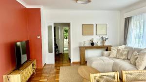 a living room with a couch and a tv at Brussels Expo & Atomium Prestige Suites in Grimbergen