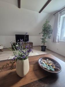 a table with a vase of flowers and a plate of snacks at Detmolder Perle 2 Charmante Dachgesschoswohnung im Altbau in Detmold