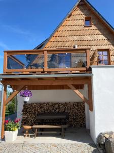 a house with a wooden roof and a bench at Ferienhaus Zirbenliebe Altenberg in Kurort Altenberg