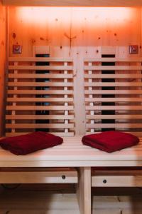 a bed with two red pillows on top of it at Ferienhaus Zirbenliebe Altenberg in Kurort Altenberg +52 photos