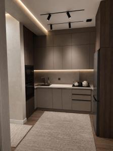 a large kitchen with a sink and a refrigerator at Современные 2-комнатные апартаменты в ЖК Capital City рядом с Shym City Park in Shymkent