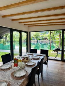 a dining room with a table and chairs and windows at Unavis Residence in Bihać