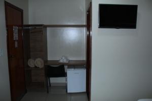a room with a desk and a television in a room at Via Hotel in Monte Alegre de Minas +11 photos