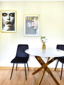 ein Esszimmer mit einem weißen Tisch und zwei Stühlen in der Unterkunft Golden Studio in Płock + 6 Fotos