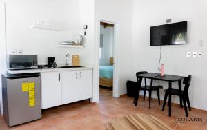 a kitchen with white cabinets and a table with a black table at Solaris Villa in Las Terrenas +4 photos