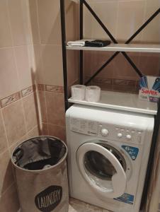 a laundry room with a washing machine and a trash can at STADIUM 1 Apartments Sandanski in Sandanski