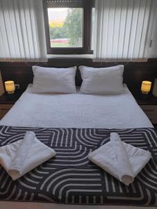 a bed with two white pillows and a window at STADIUM 1 Apartments Sandanski in Sandanski