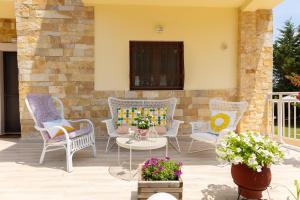 a patio with chairs and a table and some flowers at Casa Stefanos in Afitos