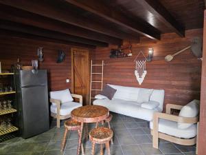 a living room with a couch and a table and a refrigerator at Refúgio do Norte in Porto Moniz