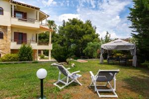 a group of chairs and an umbrella in a yard at Casa Stefanos in Afitos