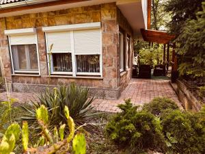 a house with a window and a brick walkway at Árnyas Tölgy in Kismaros