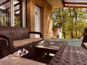 a porch with a chair and a table and a window at Árnyas Tölgy in Kismaros