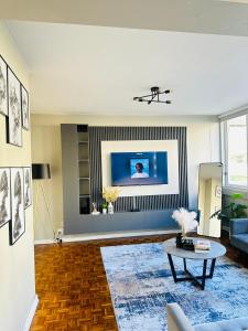 a living room with a tv on a wall at Home By The Sea in Gqeberha