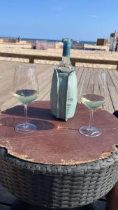 two wine glasses and a bottle on a table at Casa Svancy in Lagoa