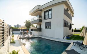 a house with a swimming pool in front of it at Villamona Dalaman in Bezkesen