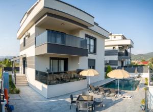 an apartment building with a swimming pool and patio at Villamona Dalaman in Bezkesen