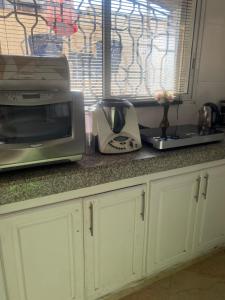 a kitchen counter with a microwave and a toaster at Comme chez moi in El Harhoura +5 photos