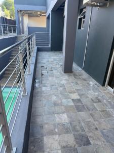 a walkway outside of a building with a staircase at Logo Luxury Guesthouse in Windhoek