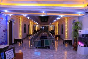 a lobby of a hotel with yellow columns and a hallway at Roshan Plaza Hotel in Kabul