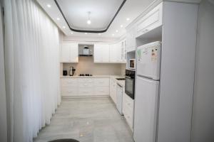 a kitchen with white cabinets and white appliances at Villamona Dalaman in Bezkesen
