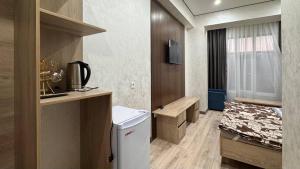 a small room with a kitchen and a bed in it at Monaco in Bosteri +31 photos
