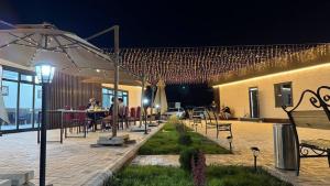 a patio with people sitting at tables under an umbrella at Monaco in Bosteri
