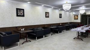 a restaurant with tables and chairs in a room at Monaco in Bosteri