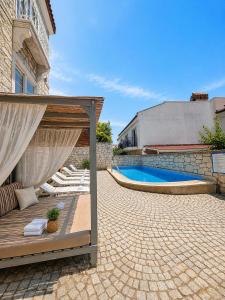 a patio with a canopy and a swimming pool at F&G Alaçatı in Alaçatı