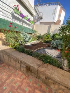 a garden in front of a building with flowers at Comme chez moi in El Harhoura