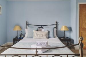 a bedroom with a large white bed with two lamps at Rathbone Cottage in Stow on the Wold