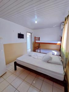 ein Schlafzimmer mit einem Bett und einem Fernseher an der Wand in der Unterkunft Pousada Sol do Centro - Dom Kilmer in Fortaleza