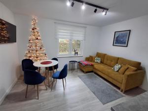 a living room with a christmas tree and a couch at Apartamenty Fredry in Lesko