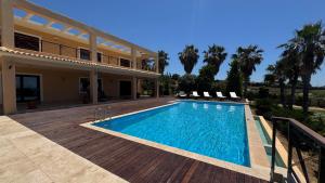 a villa with a swimming pool in front of a house at Sunset Villa in Saronida