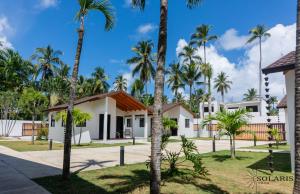 a house with palm trees in front of it at Solaris Villa in Las Terrenas