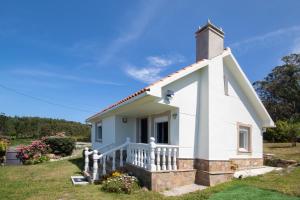 a small white chapel with a steeple at AG Casa Camariñas, con jardín y vistas al mar in Camariñas