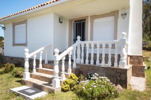 a white house with stairs and flowers at AG Casa Camariñas, con jardín y vistas al mar in Camariñas