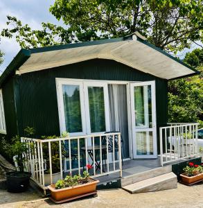 a small green house with a porch and some plants at Krupitskiy House in Chakvi