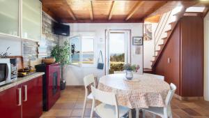 a kitchen with a table and chairs in a kitchen with a table and a table at AG Casa Camariñas, con jardín y vistas al mar in Camariñas