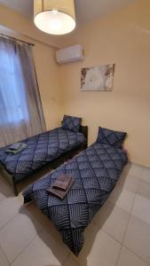 two beds sitting next to each other in a room at Venetia' s house in Kalamata