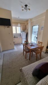 a living room with a table and a kitchen at Venetia' s house in Kalamata +4 photos