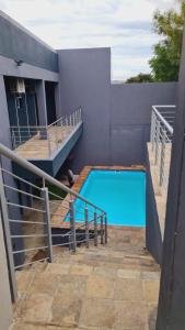 a house with a swimming pool with a cat sitting next to it at Logo Luxury Guesthouse in Windhoek