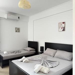 two beds in a room with white walls at Vila Llaka in Himare