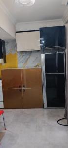 a kitchen with a refrigerator and cabinets in a room at kvartira in Kutaisi